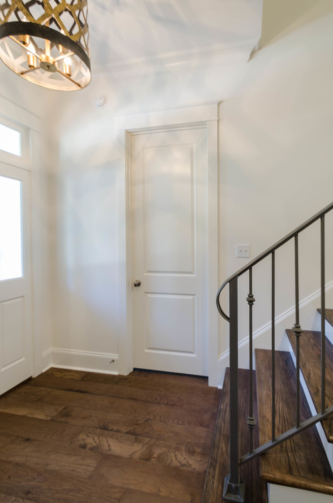 This is an example of a large traditional foyer in New Orleans with white walls, medium hardwood floors, a single front door and a white front door.
