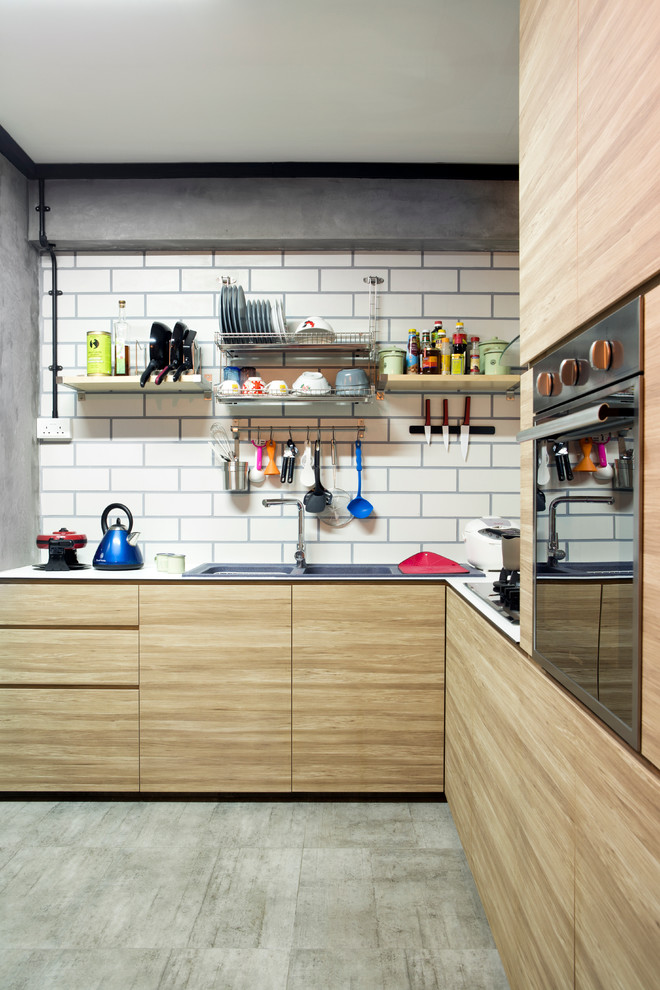 Photo of an industrial l-shaped kitchen in Singapore with flat-panel cabinets, light wood cabinets, no island, a double-bowl sink, white splashback and subway tile splashback.