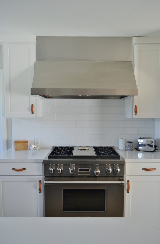 Photo of a large country l-shaped eat-in kitchen in San Francisco with an undermount sink, shaker cabinets, blue cabinets, quartz benchtops, white splashback, subway tile splashback, stainless steel appliances, light hardwood floors, brown floor and white benchtop.