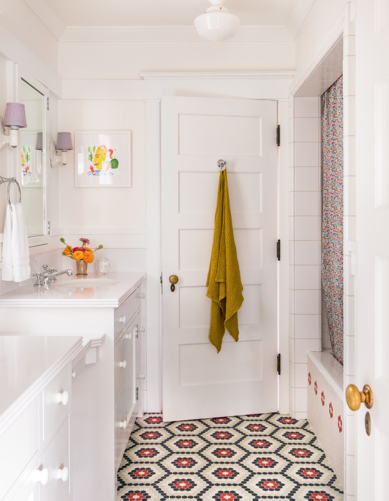 Inspiration for an arts and crafts kids bathroom in Los Angeles with beaded inset cabinets, white cabinets, an alcove tub, an alcove shower, white tile, white walls, an undermount sink, multi-coloured floor, a shower curtain and white benchtops.