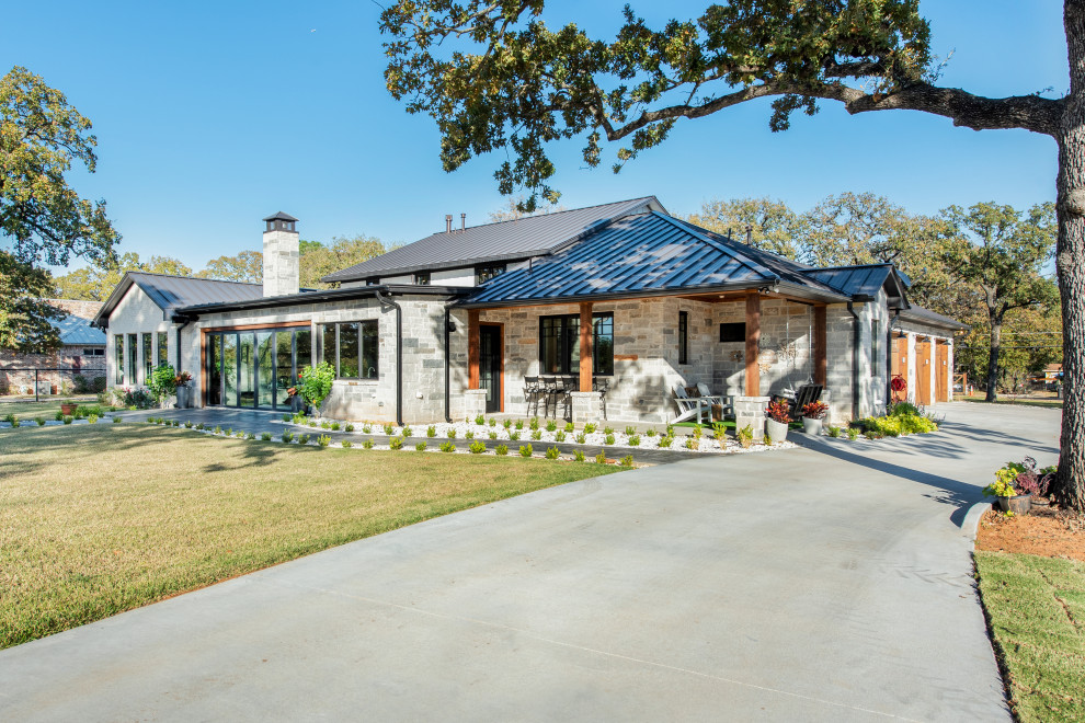 Imagen de fachada de casa gris y gris campestre de tamaño medio de una planta con revestimiento de piedra, tejado a dos aguas, tejado de metal y panel y listón