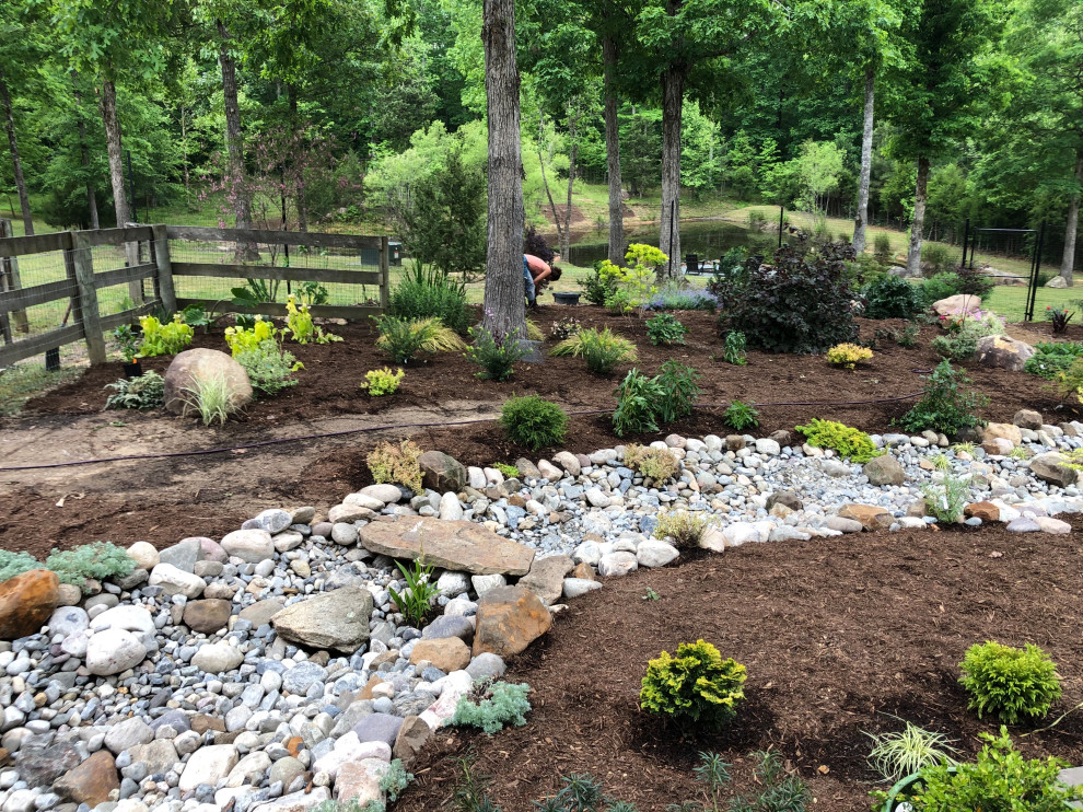 Стильный дизайн: большой регулярный сад на заднем дворе в стиле кантри с камнем в ландшафтном дизайне, полуденной тенью и покрытием из гальки - последний тренд