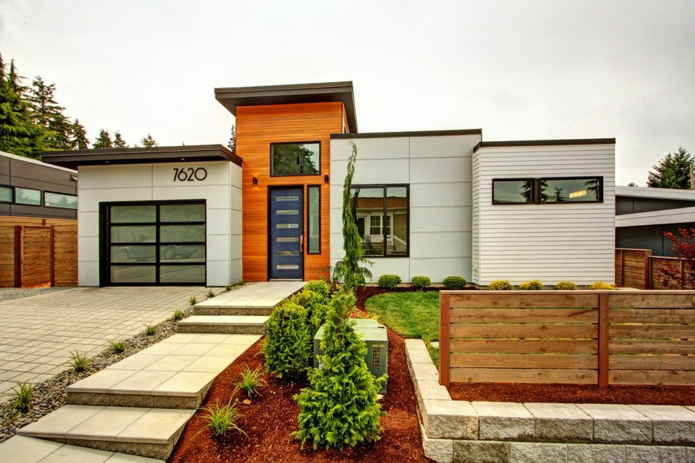This is an example of a mid-sized modern one-storey white exterior in Seattle with mixed siding.