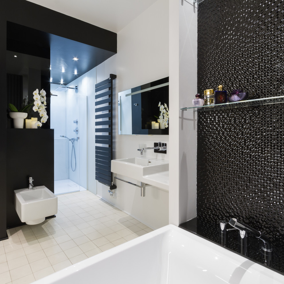 Photo of a large transitional master bathroom in Nancy with a drop-in tub, an alcove shower, a bidet, black tile, white walls and a wall-mount sink.