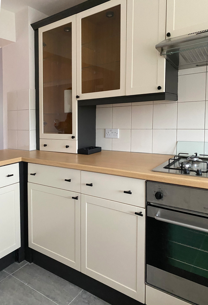 Inspiration for a small contemporary l-shaped open plan kitchen in London with an undermount sink, shaker cabinets, beige cabinets, laminate benchtops, beige splashback, ceramic splashback, stainless steel appliances, porcelain floors, a peninsula, pink floor and brown benchtop.