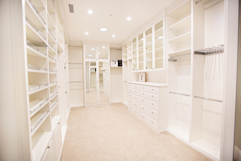 Inspiration for a large transitional gender-neutral walk-in wardrobe in Orange County with white cabinets, carpet and open cabinets.