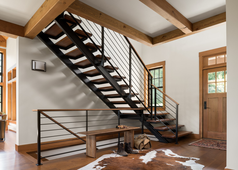 На фото: металлическая лестница в стиле рустика с деревянными ступенями и металлическими перилами с