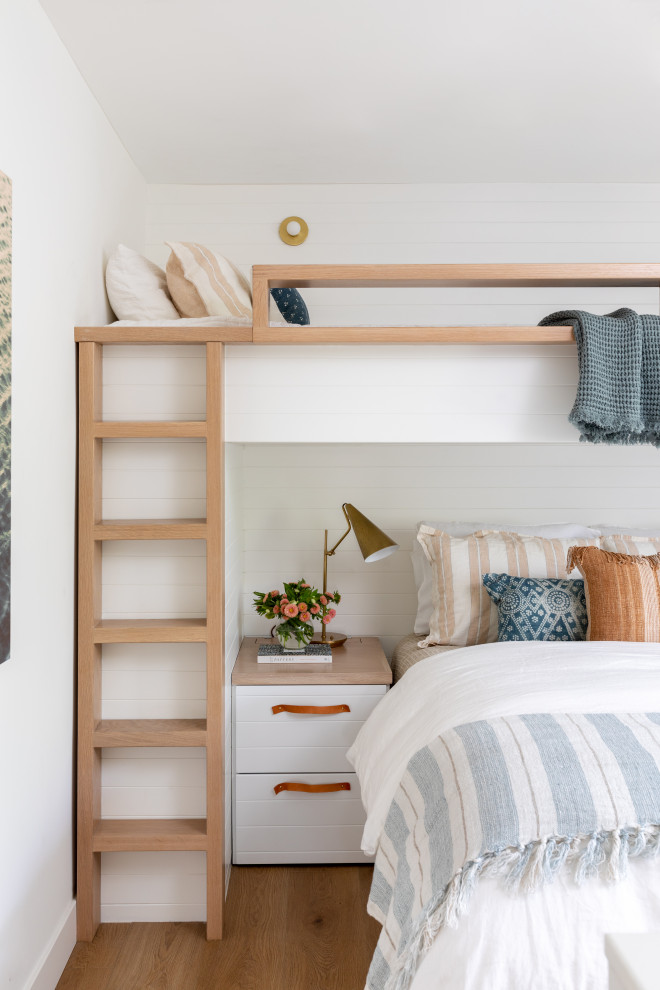 Foto de dormitorio costero con paredes blancas, suelo de madera en tonos medios, suelo marrón y machihembrado