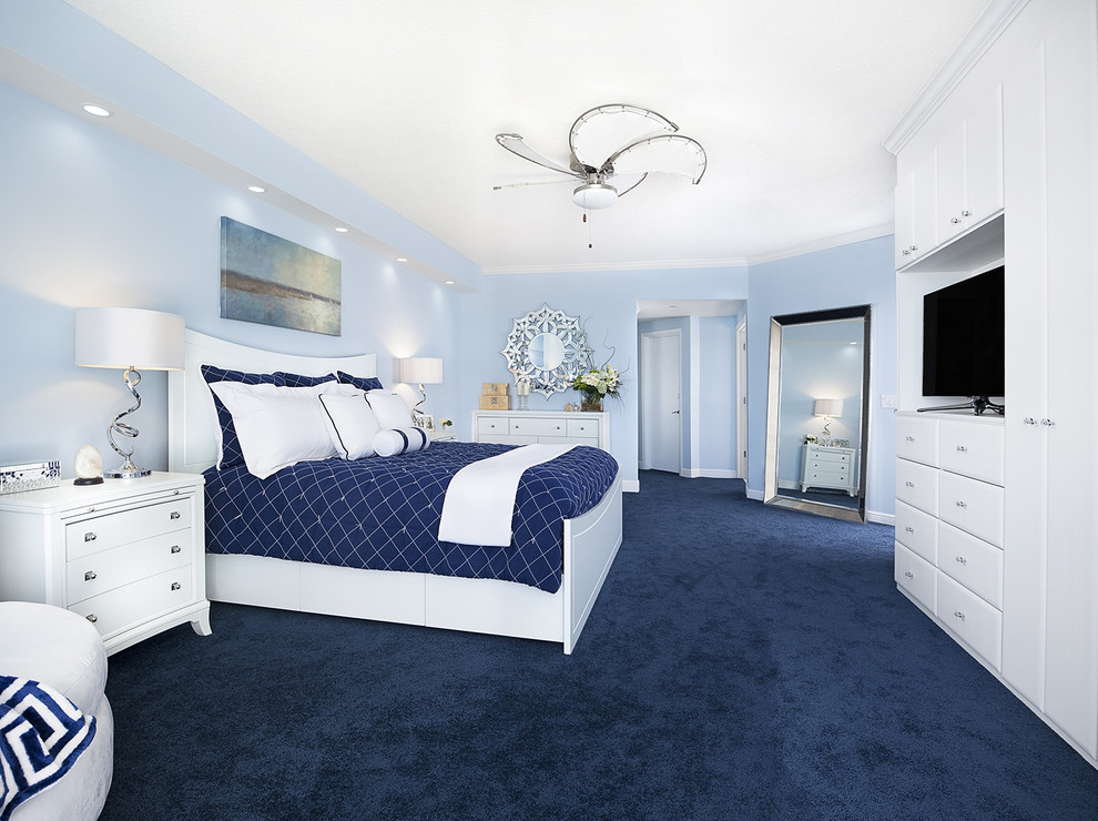 Photo of a large beach style master bedroom in Miami with blue walls, carpet and blue floor.