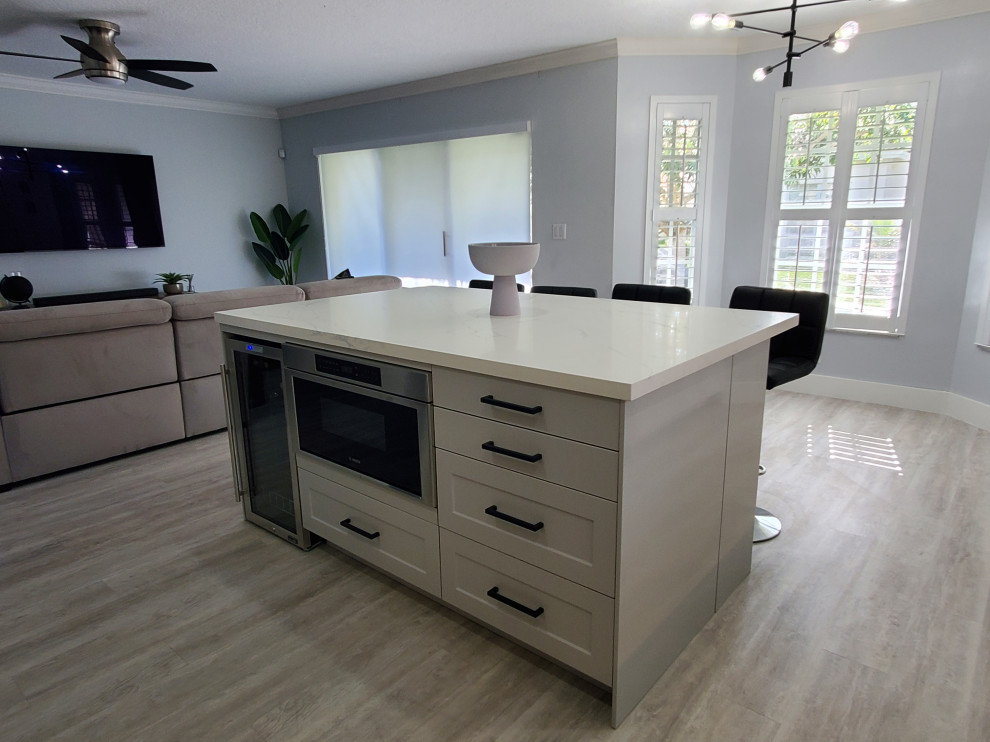 Kitchen pantry - large transitional l-shaped kitchen pantry idea in Miami with shaker cabinets, white cabinets, quartz countertops and an island