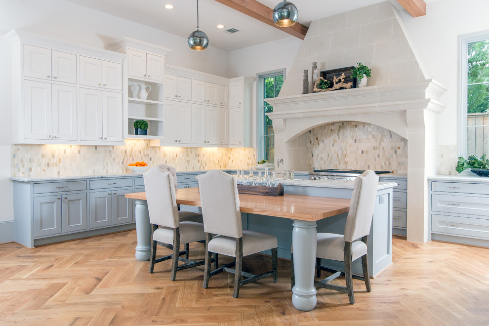 Inspiration for an expansive traditional l-shaped eat-in kitchen in Houston with multi-coloured splashback, mosaic tile splashback, light hardwood floors, with island, an undermount sink, stainless steel appliances, beige floor, raised-panel cabinets, grey cabinets, granite benchtops and grey benchtop.