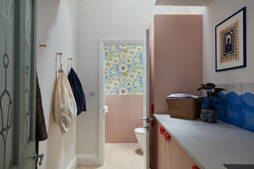 ロンドンにある小さなエクレクティックスタイルのおしゃれなランドリールーム (I型、シングルシンク、フラットパネル扉のキャビネット、クオーツストーンカウンター、青いキッチンパネル、白い壁、コルクフローリング、洗濯乾燥機、グレーのキッチンカウンター) の写真