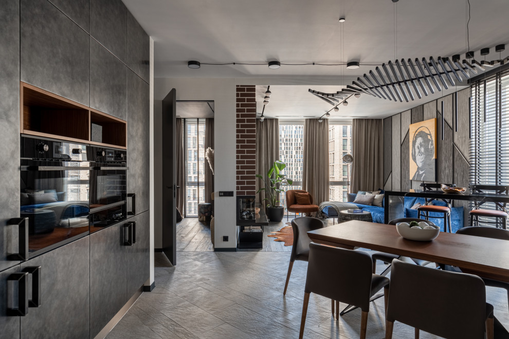 Стильный дизайн: угловая кухня-гостиная в современном стиле с плоскими фасадами, фасадами из нержавеющей стали и полуостровом - последний тренд