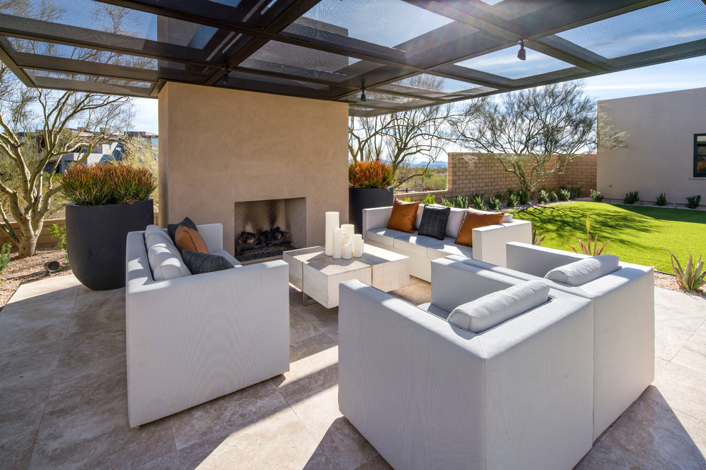 Contemporary patio in Phoenix with an awning and with fireplace.