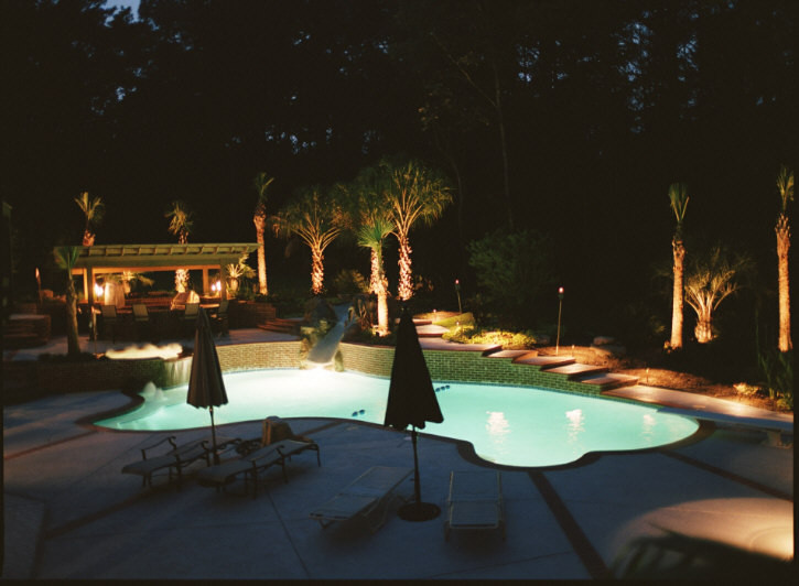 This is an example of a large traditional backyard custom-shaped pool in Other with a hot tub and brick pavers.