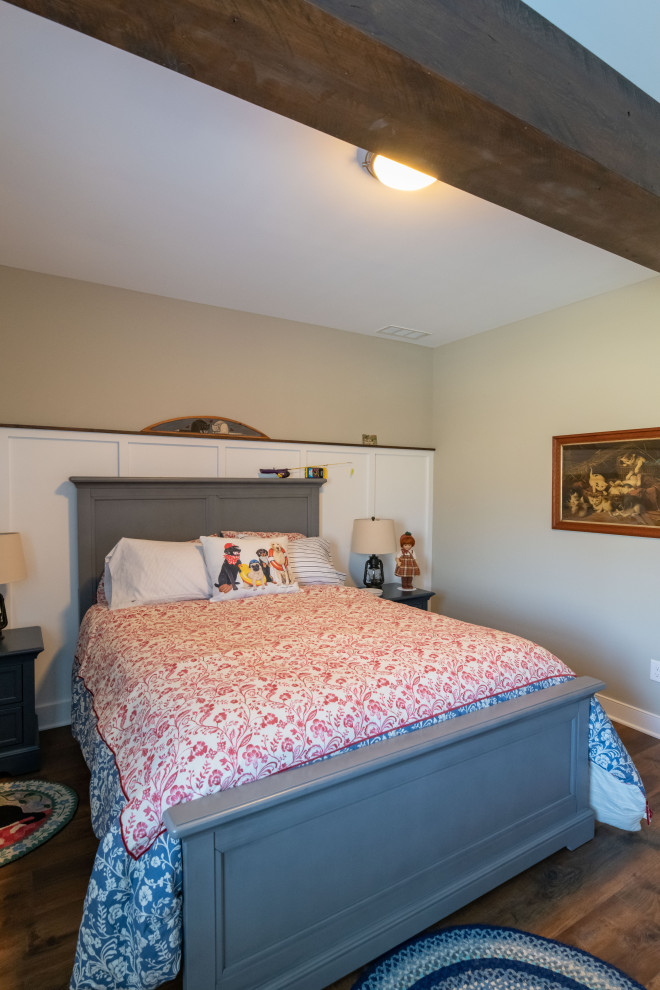 Imagen de habitación de invitados de estilo de casa de campo con paredes beige, vigas vistas y panelado