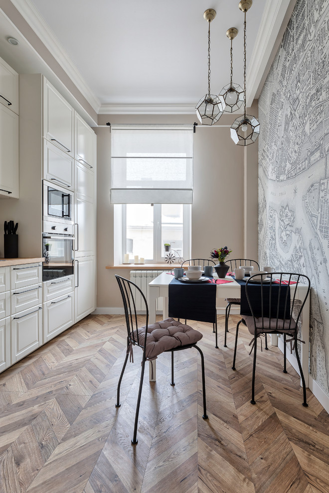 This is an example of a small traditional kitchen/dining combo in Saint Petersburg with multi-coloured walls, light hardwood floors and no fireplace.