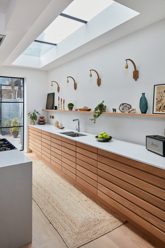 Inredning av ett minimalistiskt mellanstort kök med öppen planlösning, med bänkskiva i koppar och en köksö