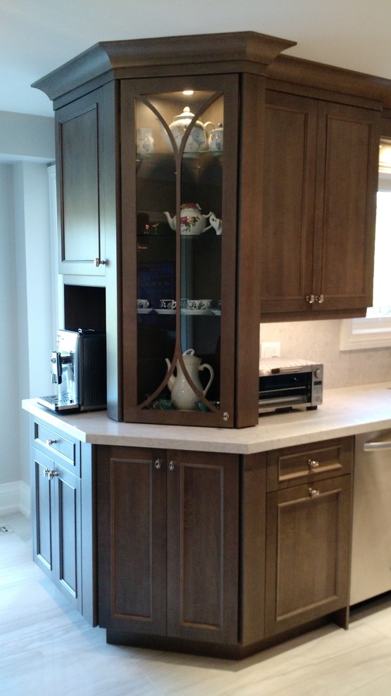 Example of a large transitional u-shaped porcelain tile eat-in kitchen design with an undermount sink, medium tone wood cabinets, solid surface countertops, stone slab backsplash, stainless steel appliances and an island