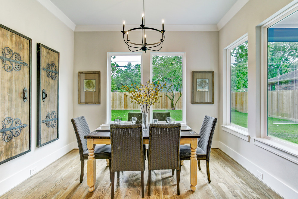 This is an example of a large country dining room in Houston with black walls, medium hardwood floors and brown floor.