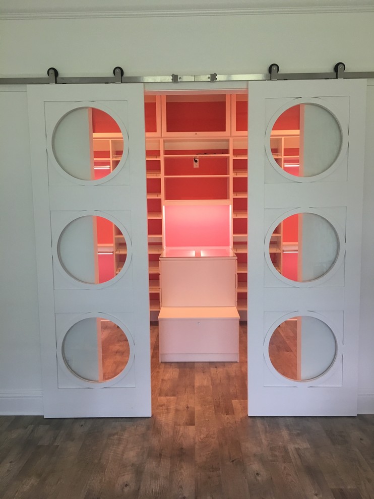 Inspiration for a large modern women's walk-in wardrobe in Other with raised-panel cabinets, white cabinets, vinyl floors and brown floor.