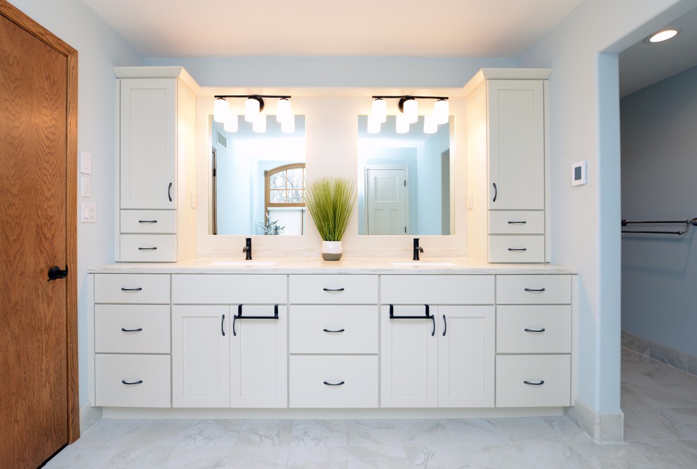 Corner bathtub - mid-sized transitional master white tile and stone tile porcelain tile and white floor corner bathtub idea with shaker cabinets, white cabinets, a one-piece toilet, blue walls, an integrated sink, solid surface countertops, a hinged shower door and white countertops