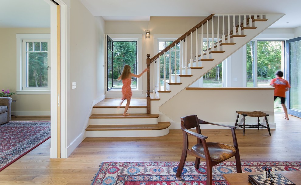 This is an example of a mid-sized country wood l-shaped staircase in Boston with wood railing and painted wood risers.