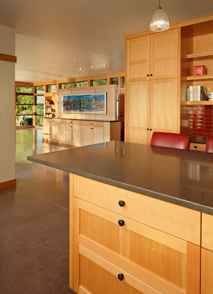 Mid-sized midcentury u-shaped open plan kitchen in Seattle with recessed-panel cabinets, light wood cabinets, limestone benchtops, stainless steel appliances, concrete floors, with island, grey floor and brown benchtop.