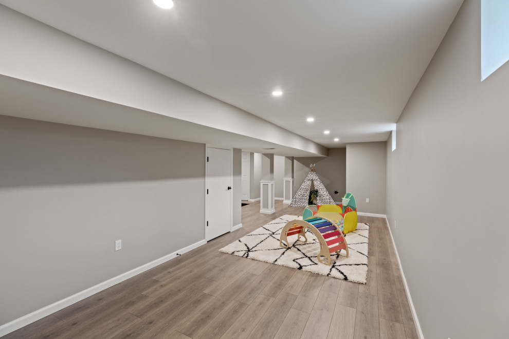 Design ideas for a mid-sized modern fully buried basement in Philadelphia with a game room, grey walls, vinyl floors and brown floor.