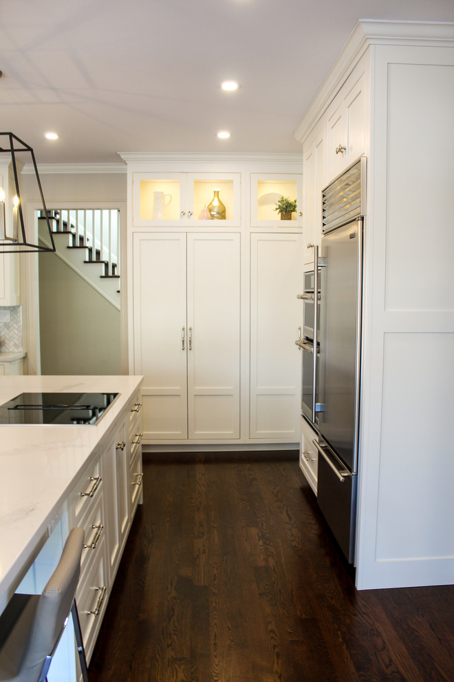 Eat-in kitchen - mid-sized transitional u-shaped dark wood floor and brown floor eat-in kitchen idea in Toronto with an undermount sink, shaker cabinets, white cabinets, quartzite countertops, multicolored backsplash, mosaic tile backsplash, stainless steel appliances, an island and white countertops