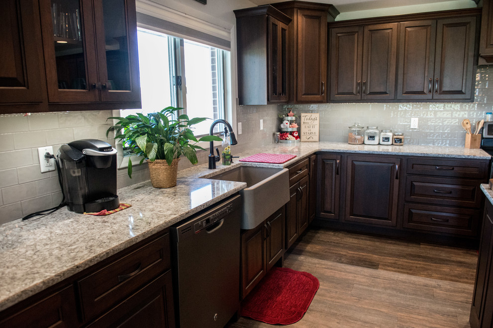 Open concept kitchen - huge transitional l-shaped medium tone wood floor open concept kitchen idea with a farmhouse sink, raised-panel cabinets, medium tone wood cabinets, quartz countertops, gray backsplash, subway tile backsplash, stainless steel appliances, an island and multicolored countertops
