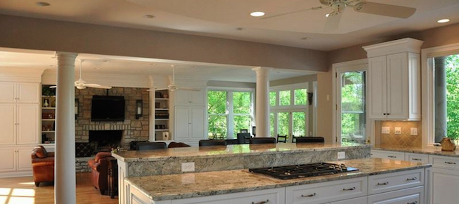 Eat-in kitchen - light wood floor eat-in kitchen idea with recessed-panel cabinets, white cabinets, granite countertops, beige backsplash and an island
