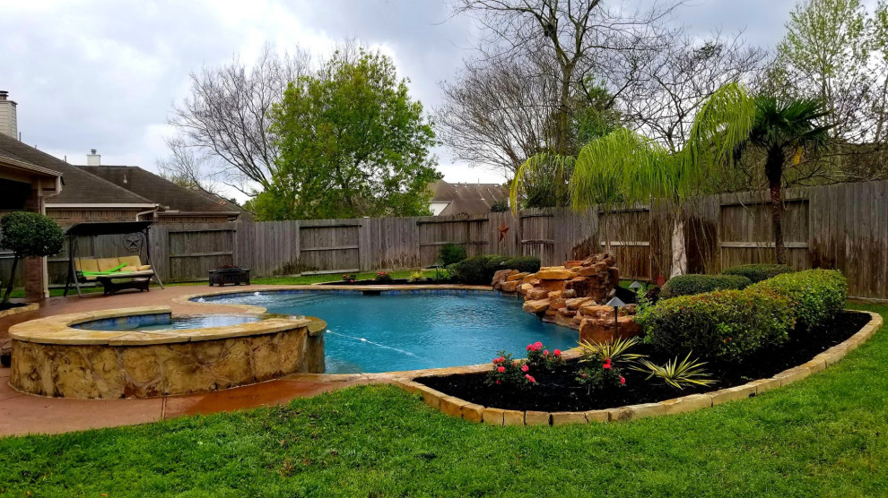 Photo of a mid-sized traditional backyard full sun formal garden for summer in Other with with flowerbed and natural stone pavers.