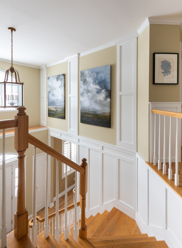 Mittelgroßes Foyer mit weißer Wandfarbe, hellem Holzboden, gewölbter Decke und Wandpaneelen in Sonstige
