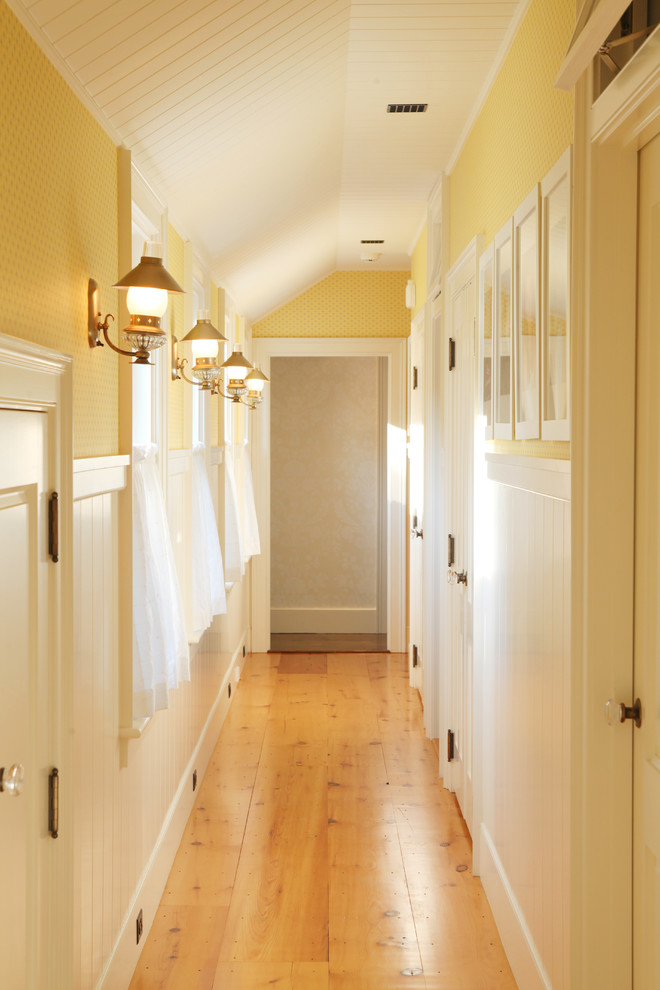 Design ideas for a mid-sized country hallway in Boston with yellow walls, medium hardwood floors and yellow floor.