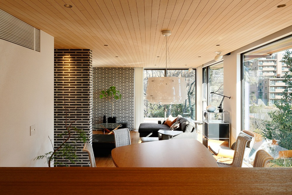 Offenes Modernes Esszimmer mit weißer Wandfarbe, hellem Holzboden und braunem Boden in Kobe