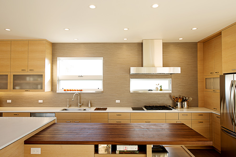 Modern kitchen in San Francisco with stainless steel appliances, wood benchtops, flat-panel cabinets, light wood cabinets and matchstick tile splashback.