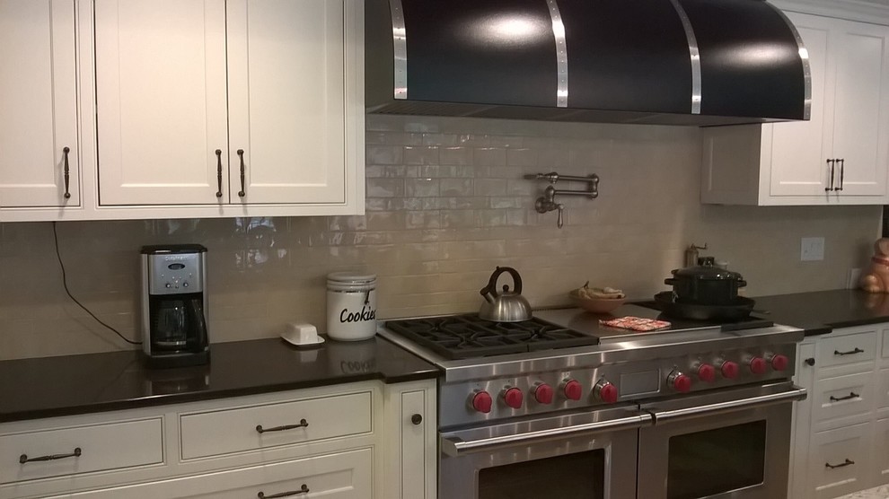 Example of a transitional kitchen design in Minneapolis with recessed-panel cabinets, white cabinets, granite countertops and beige backsplash