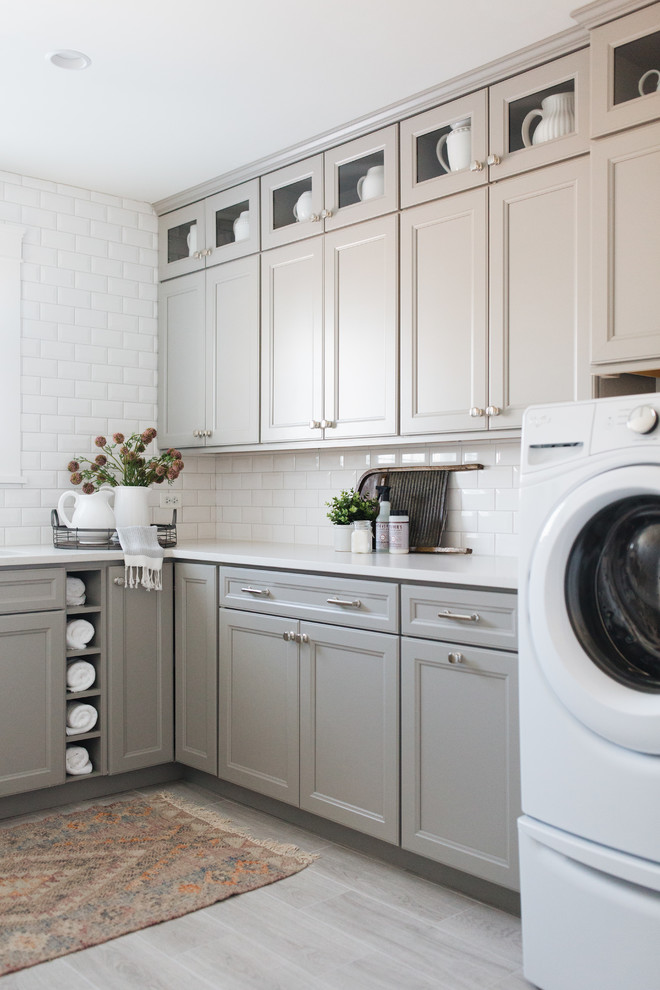 Transitional laundry room in Chicago with recessed-panel cabinets, white walls, a side-by-side washer and dryer, beige floor and grey cabinets.