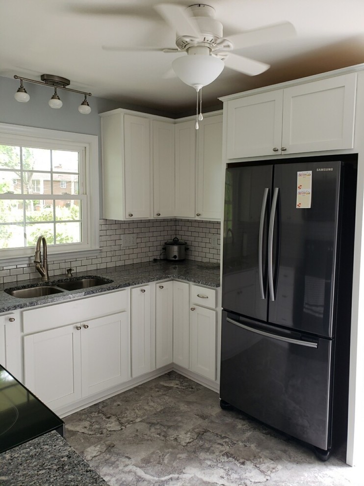 Small mountain style u-shaped vinyl floor and gray floor enclosed kitchen photo with an undermount sink, shaker cabinets, white cabinets, granite countertops, white backsplash, subway tile backsplash, black appliances, no island and multicolored countertops