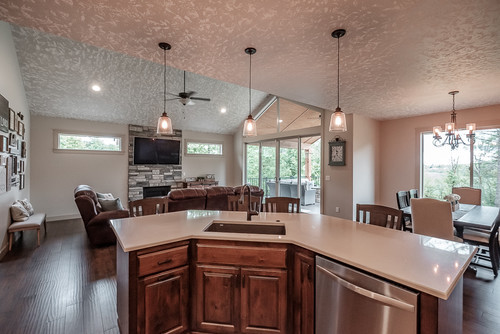 Brown floor open concept kitchen photo in Portland with an undermount sink, raised-panel cabinets, medium tone wood cabinets, stainless steel appliances, an island and white countertops
