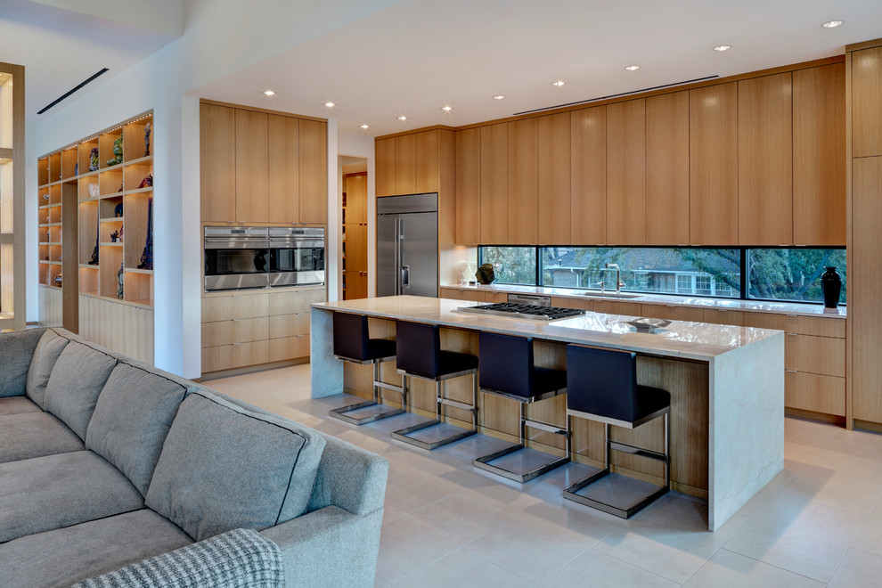 This is an example of a contemporary l-shaped open plan kitchen in Dallas with an integrated sink, flat-panel cabinets, light wood cabinets and stainless steel appliances.