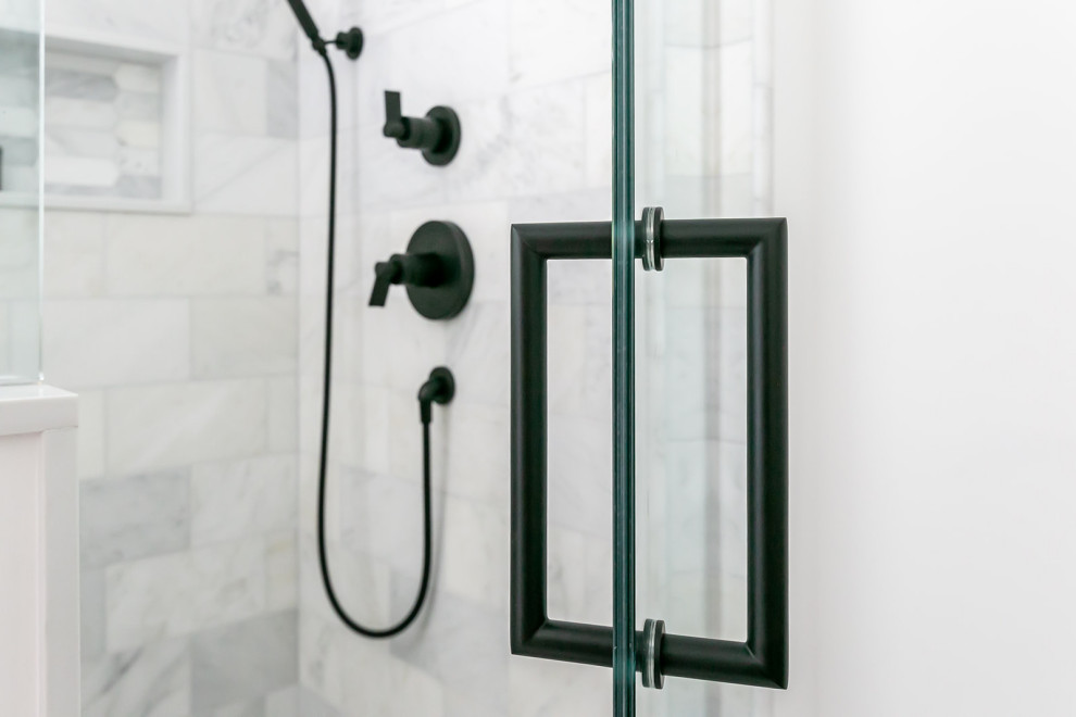 This is an example of a mid-sized transitional master bathroom in Baltimore with furniture-like cabinets, medium wood cabinets, a freestanding tub, a corner shower, a two-piece toilet, white tile, marble, white walls, ceramic floors, an undermount sink, engineered quartz benchtops, white floor, a hinged shower door, white benchtops, a niche, a double vanity and a freestanding vanity.