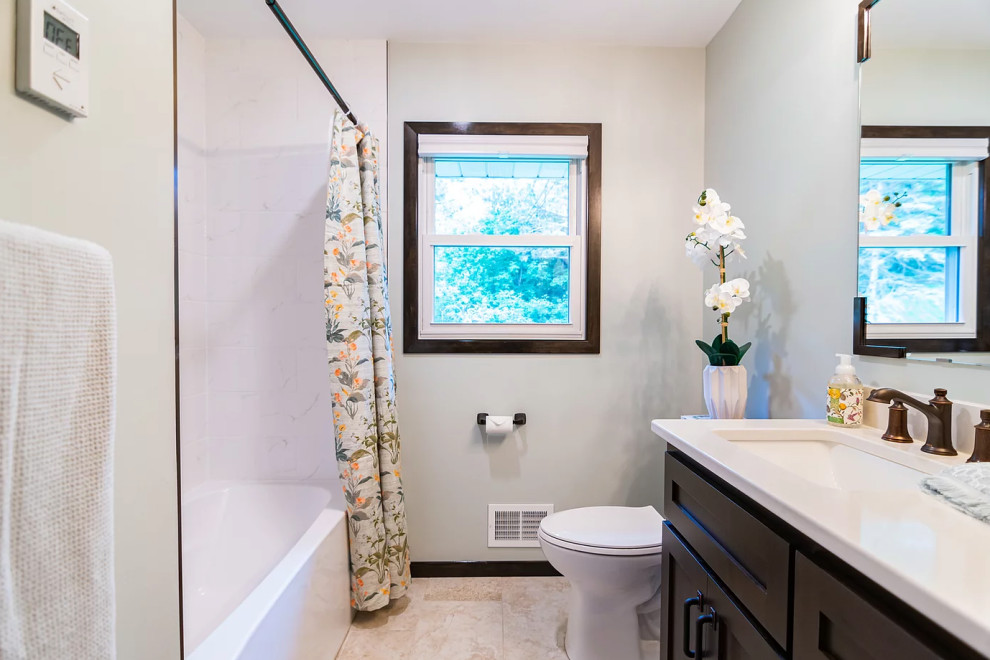 Пример оригинального дизайна: маленькая ванная комната, совмещенная с туалетом в классическом стиле с фасадами в стиле шейкер, темными деревянными фасадами, ванной в нише, душем над ванной, белой плиткой, керамической плиткой, синими стенами, полом из керамической плитки, врезной раковиной, столешницей из искусственного кварца, коричневым полом, шторкой для ванной, белой столешницей, нишей, тумбой под одну раковину и напольной тумбой для на участке и в саду