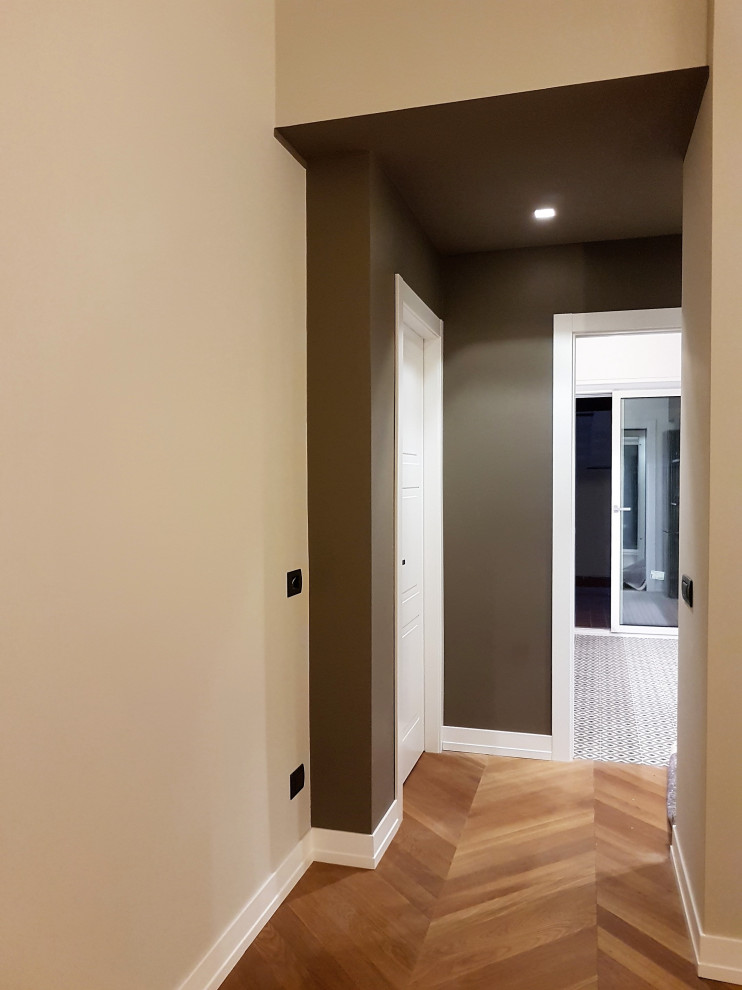 Immagine di un ingresso o corridoio design con pareti marroni, parquet chiaro e soffitto ribassato