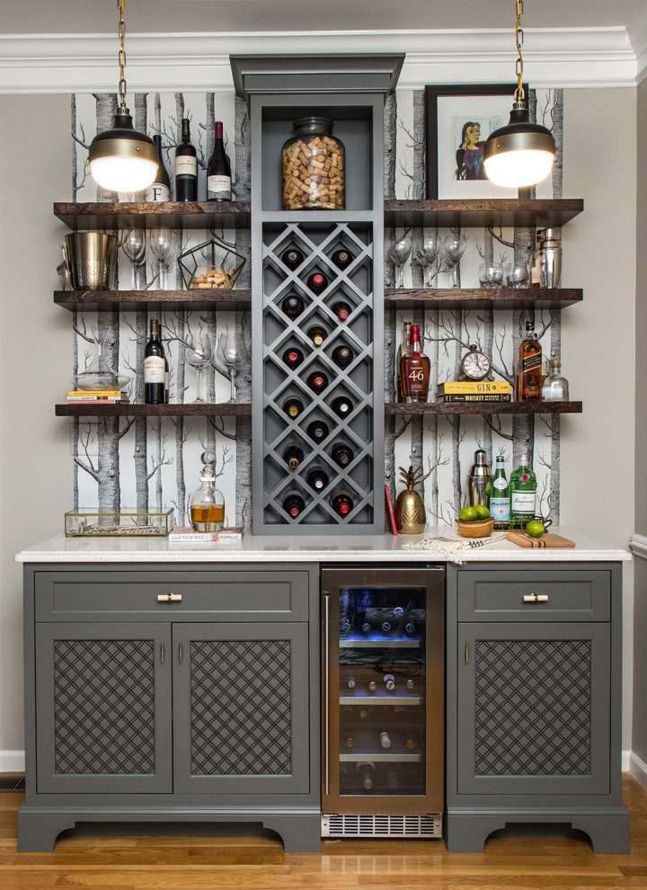 Inspiration for a mid-sized transitional single-wall wet bar in Chicago with shaker cabinets, grey cabinets, quartz benchtops, medium hardwood floors and white benchtop.