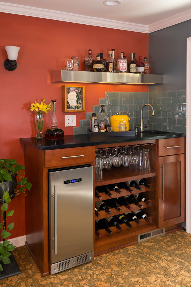 Inspiration for a small eclectic single-wall wet bar in Other with an undermount sink, shaker cabinets, medium wood cabinets, solid surface benchtops, grey splashback, glass tile splashback and cork floors.