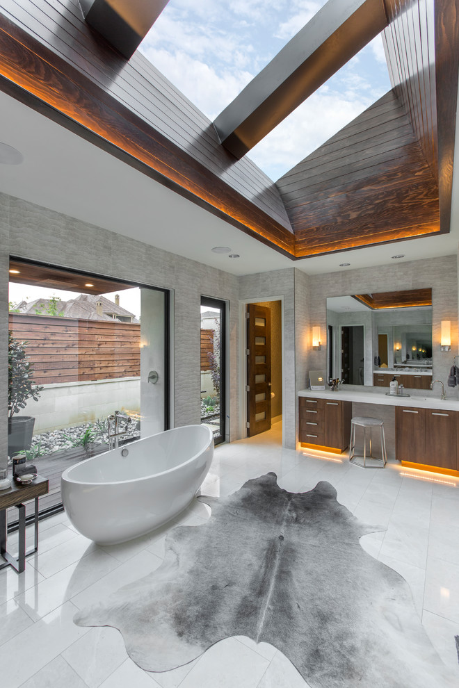 Inspiration for an expansive contemporary master bathroom in Dallas with flat-panel cabinets, medium wood cabinets, a freestanding tub, an urinal, gray tile and a hinged shower door.