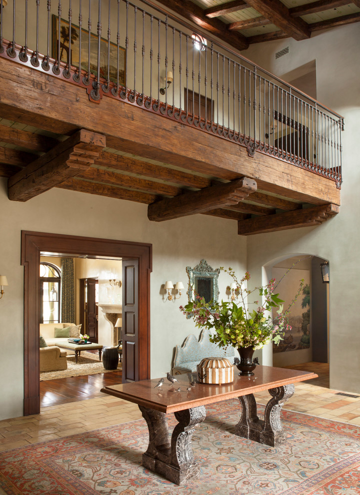 This is an example of a large mediterranean foyer in Los Angeles with grey walls and brick floors.