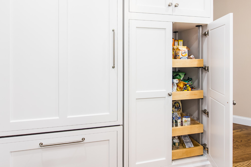 Design ideas for a mid-sized traditional u-shaped kitchen pantry in Boston with an undermount sink, shaker cabinets, stainless steel appliances, dark hardwood floors, with island, white cabinets, granite benchtops, beige splashback and porcelain splashback.
